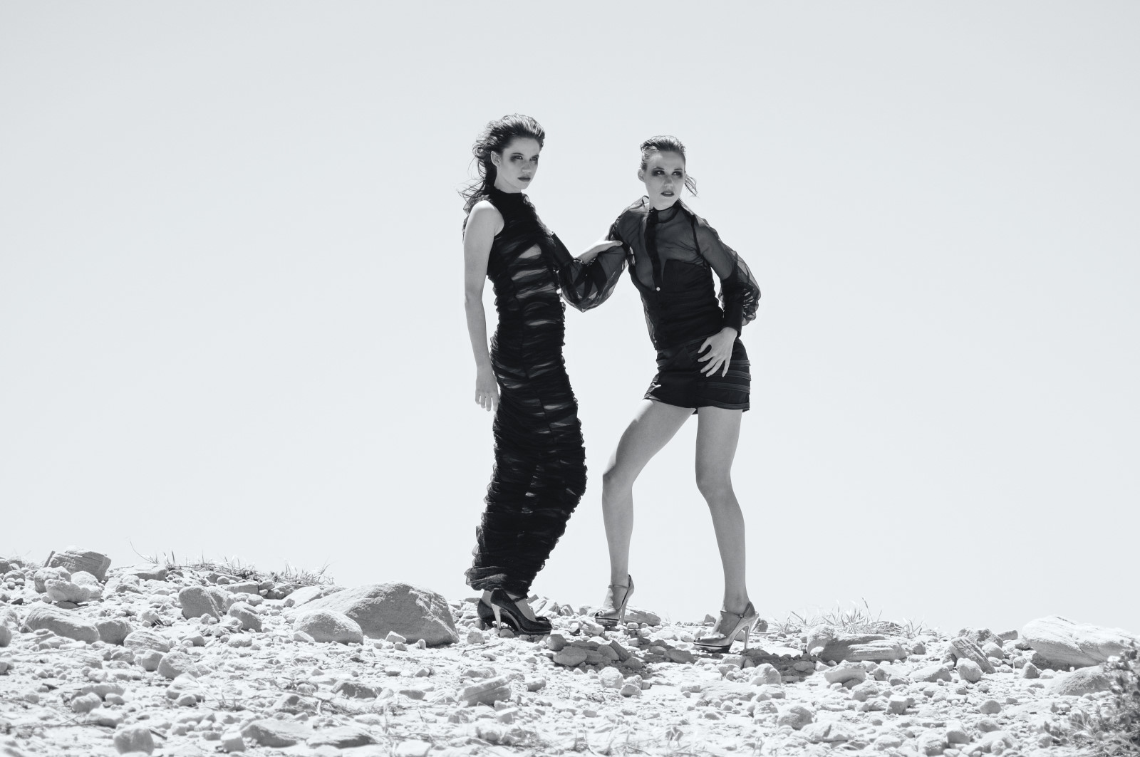 B&W Fashion Editorial Photography Sydney, The Girls Who Fell To Earth, two on a white rock mound, black sheer dresses.