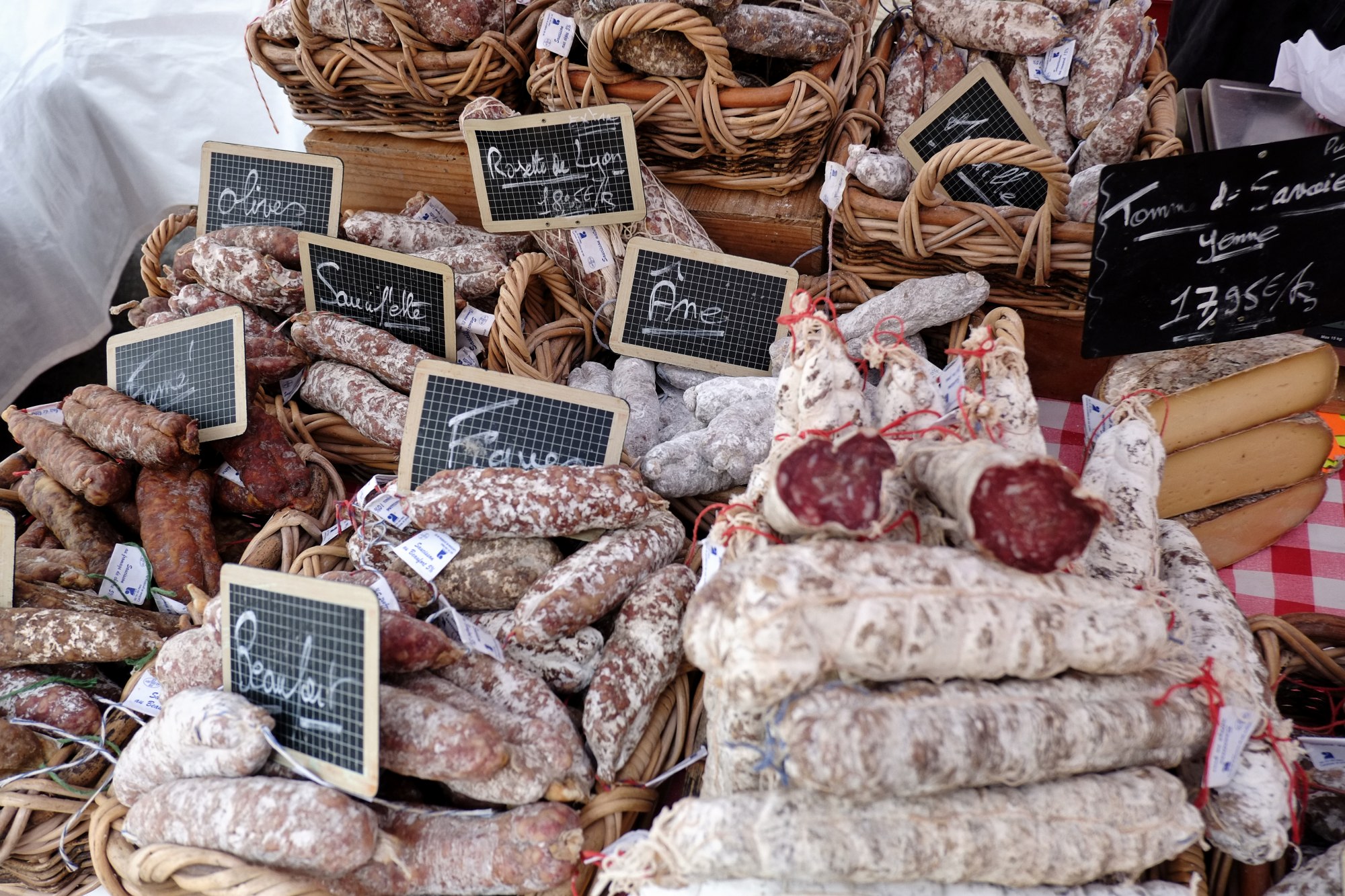 A wide variety of French Saucisson, sausages market day in Le Bois-d'Oingt. Food and travel lifestyle photography by Kent Johnson.