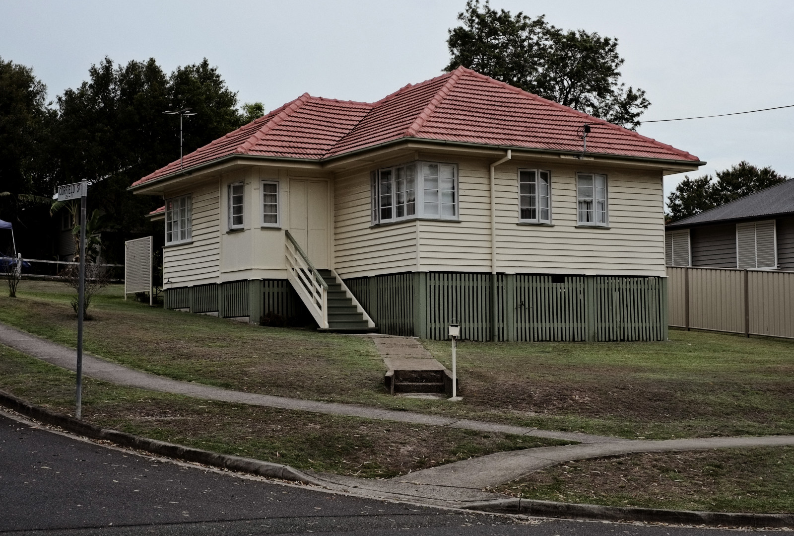 Origninal condition weatherboard home with timber fenestration on understory, casement windows on an unimproved and unfenced corner block in Carina. Post WW2 Brisbane vernacular architecture. Architectural photography by Kent Johnson.