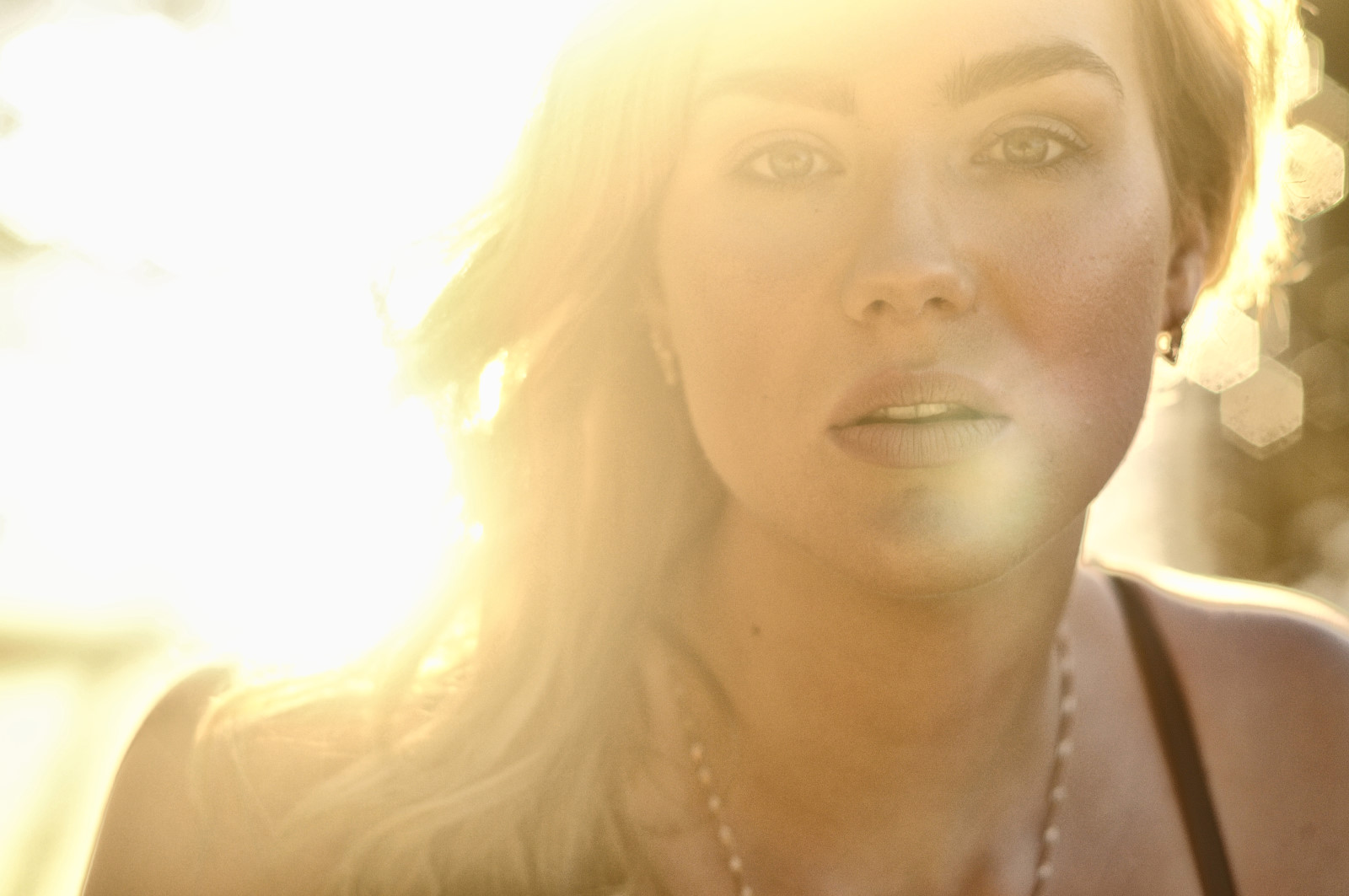 Backlit horizontal headshot with lensflare. Beauty Photography by Kent Johnson.