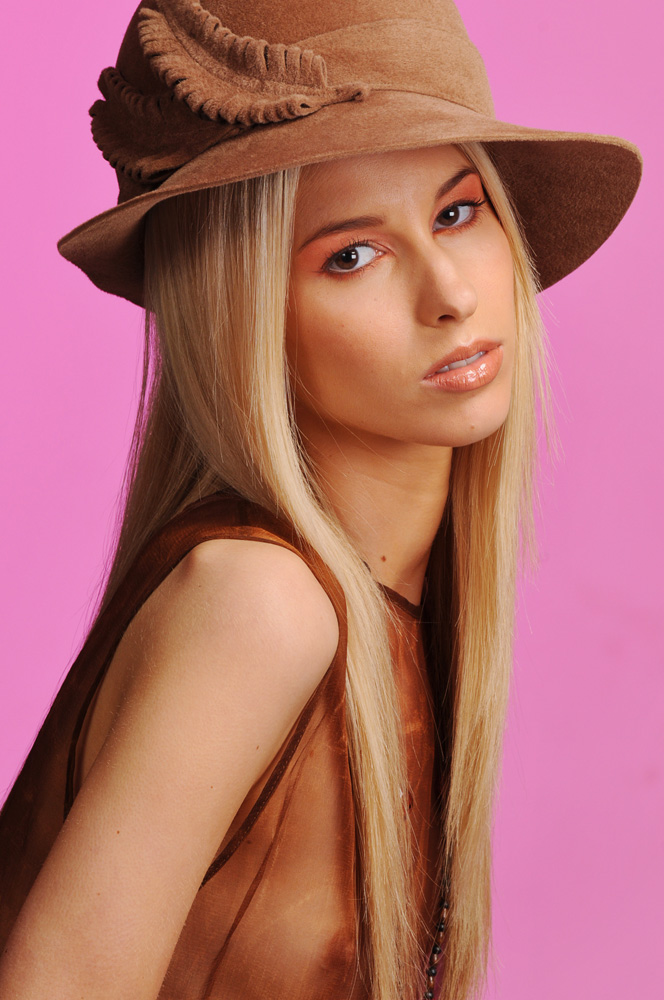 A felt feather in her cap.. Colour Hats & Beauty in The Studio, Brown Hat, Pink Background