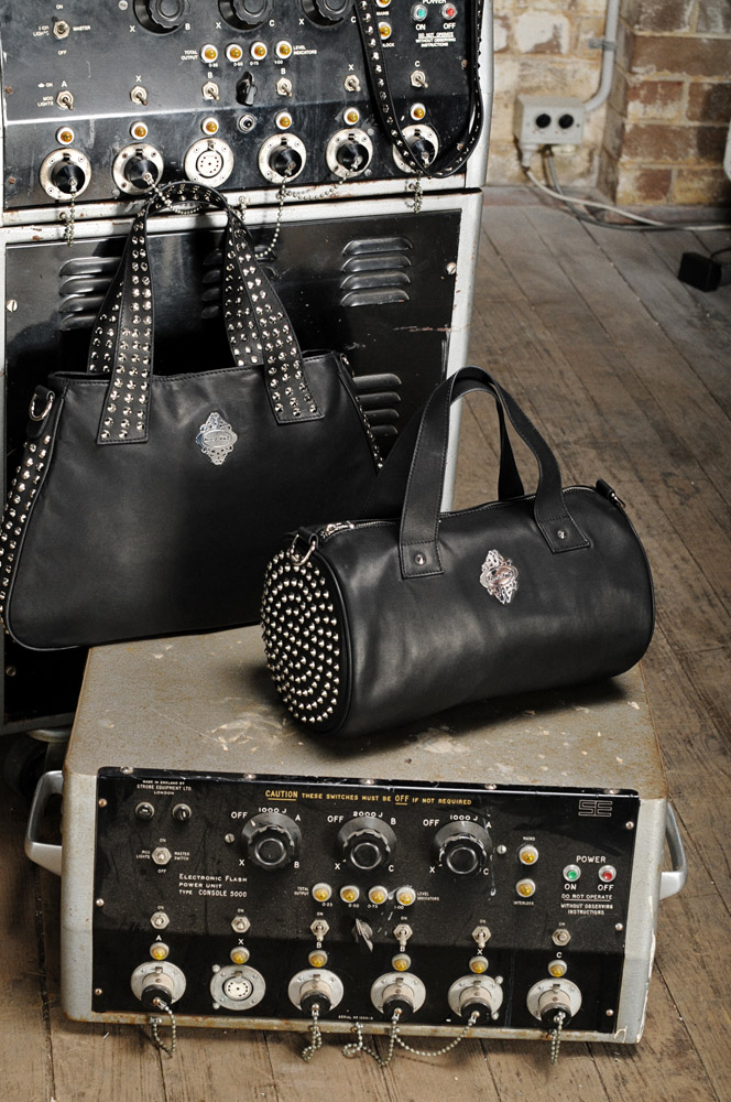 Product shot of handbags on old electric consoles, wodden floor, brick wall.