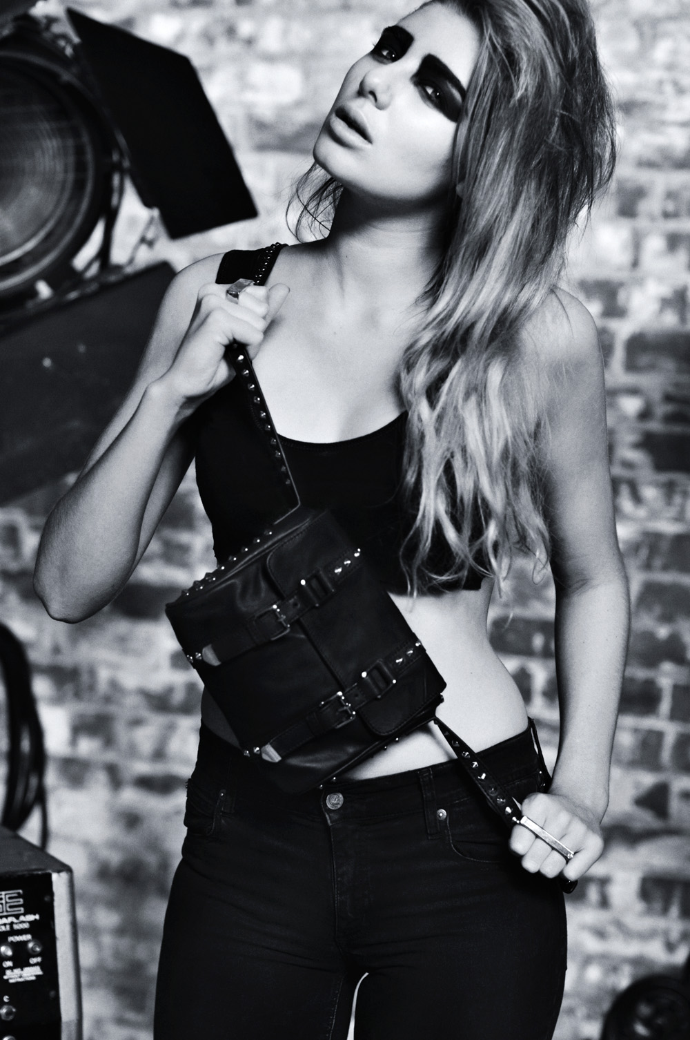 Sydney fashion model photographed with small satchel in black and white. Biker fashion inspired handbag branding campaign. Photography by Kent Johnson.