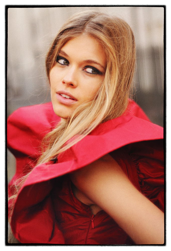 Fashion shoot Hero headshot of model in red dress with huge shoulder sleeves.