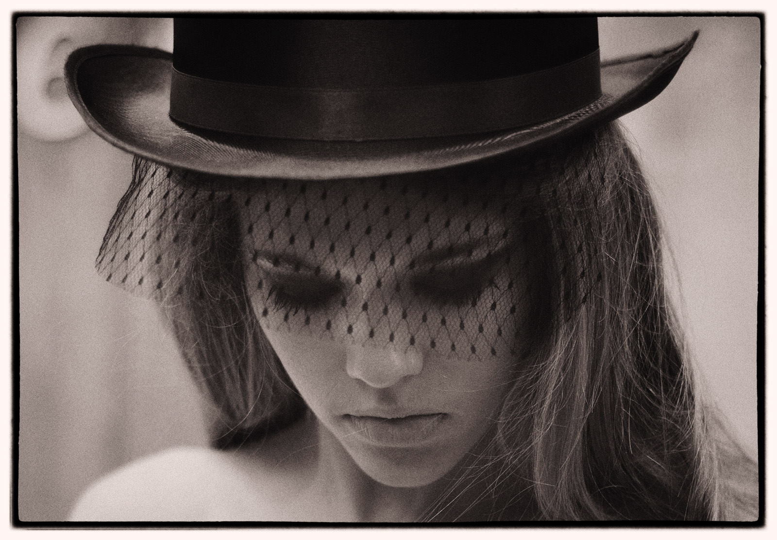 A black & white fashion campaign headshot of Victoria in top hat and black veil - fashion photograph on location by Kent Johnson, Sydney, Australia.