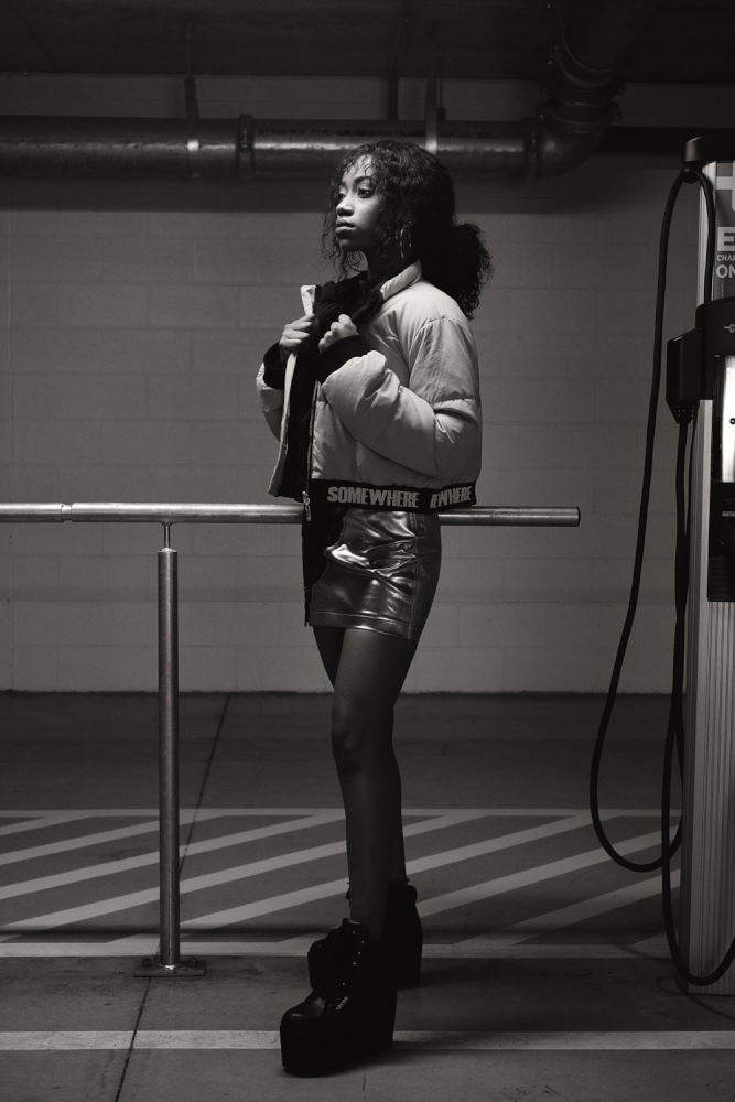 Model in puff jacket and meatalic skirt, elevator boots. Parking garage photoshoot in Sydney for Somewhere Label. Fashion photography by Kent Johnson