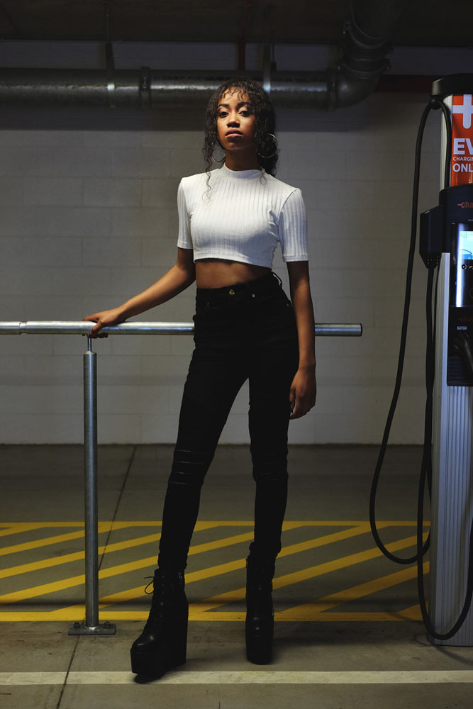 Model in white ribbed crop top and jeans. Parking garage photoshoot in Sydney for Somewhere Label. Fashion photography by Kent Johnson