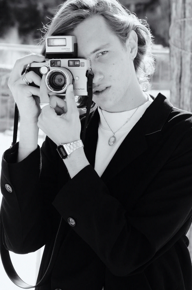 Male model with vintage camera, black and white picture taken on location.