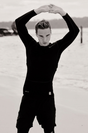 Leo on the beach in black running kit, Sydney, Australia.