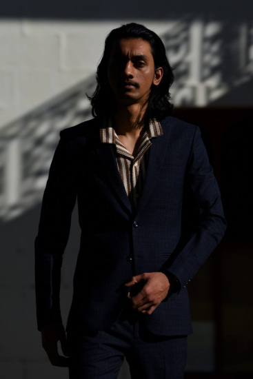 Male model dark suit and striped shirt.
