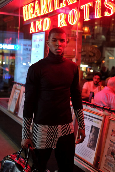 Afro American male model in a wash of red neon light under the Empire State Building - Menswear photographed in New York City by Kent Johnson.