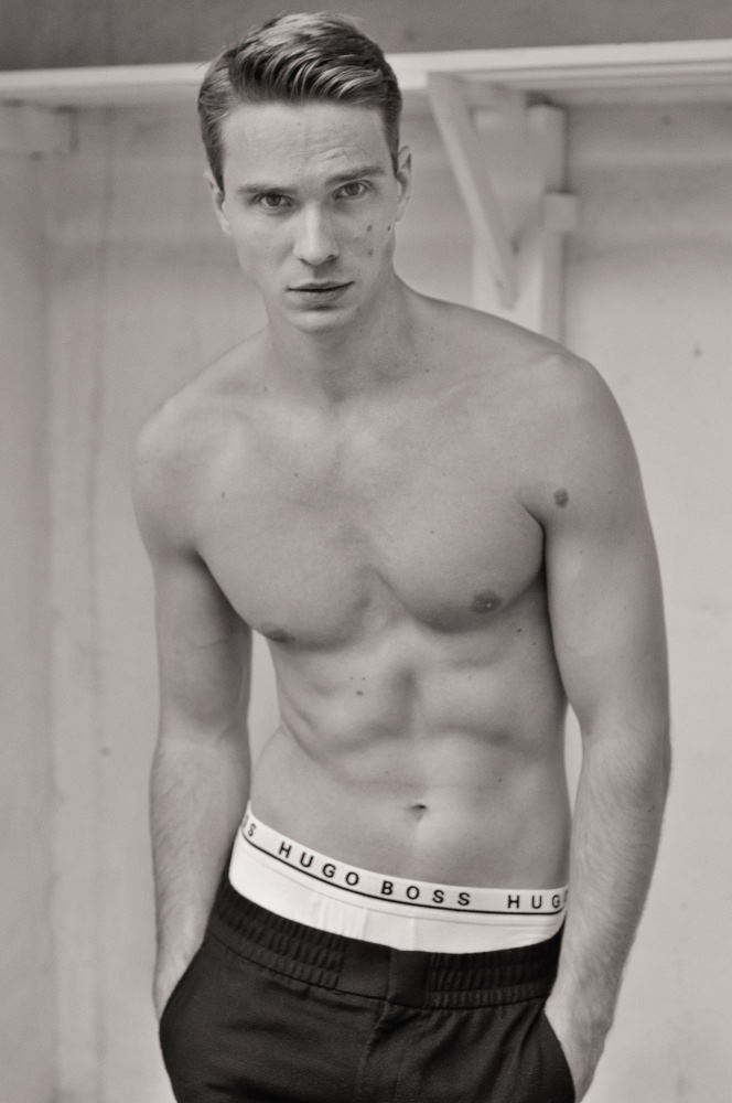 Leo, shirt off, sportswear mid shot in black and white - Male modelling agency portfolio photo-shoot by Kent Johnson.
