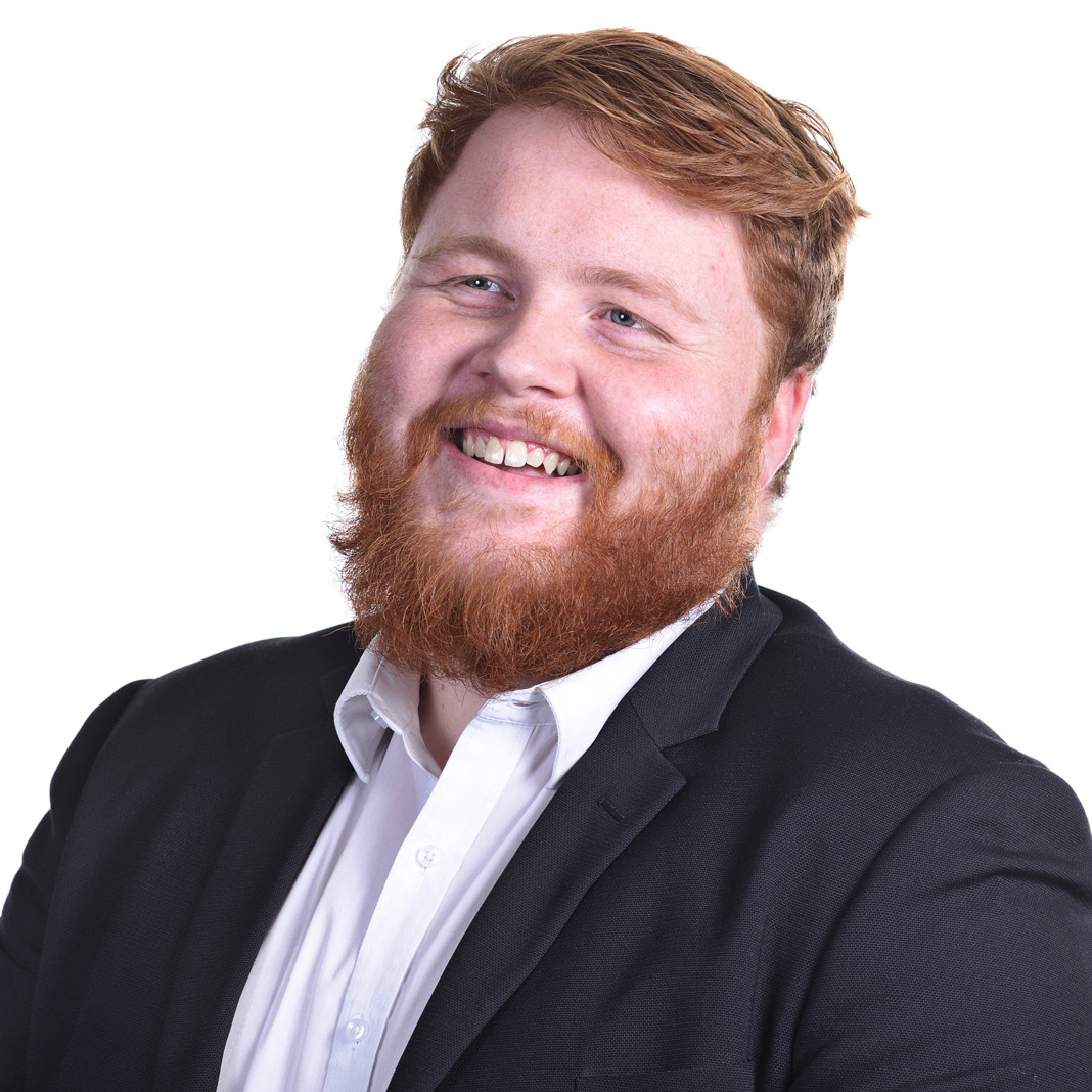 Corporate Headshot of a man in jacket white shirt and red tie, photographed with an onsite studio by Kent Johnson.