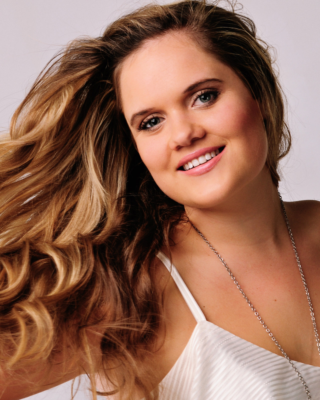 Young woman with great hair and smile, portrait in the studio. Photographed by Kent Johnson.