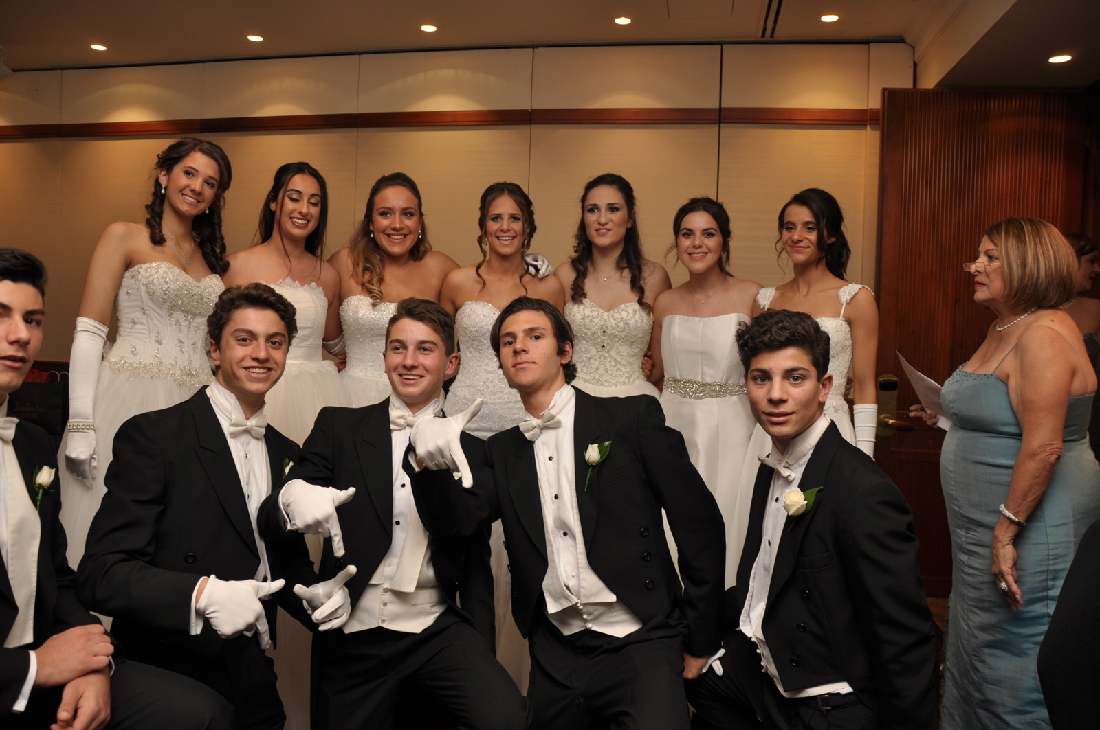 Young debutant women in elegant dresses and young men in suits with tails at a debutant ball in Sydney, Australia.
