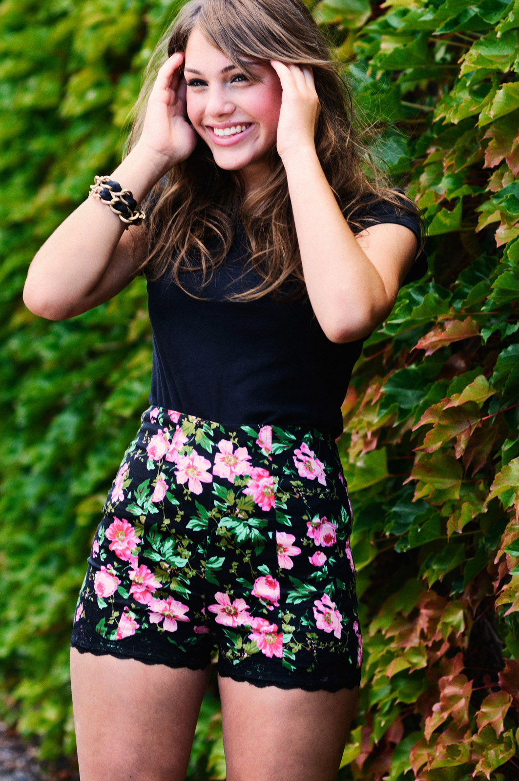 Young smiling woman standing against a wall of ivy, fashion portrait by Kent Johnson Photography, Sydney, Australia.