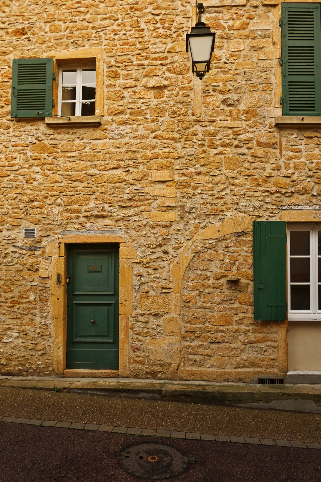 A classic Golden Stone house with green shutters in Le Bois-d'Oingt. Architectural travel photography by Kent Johnson.