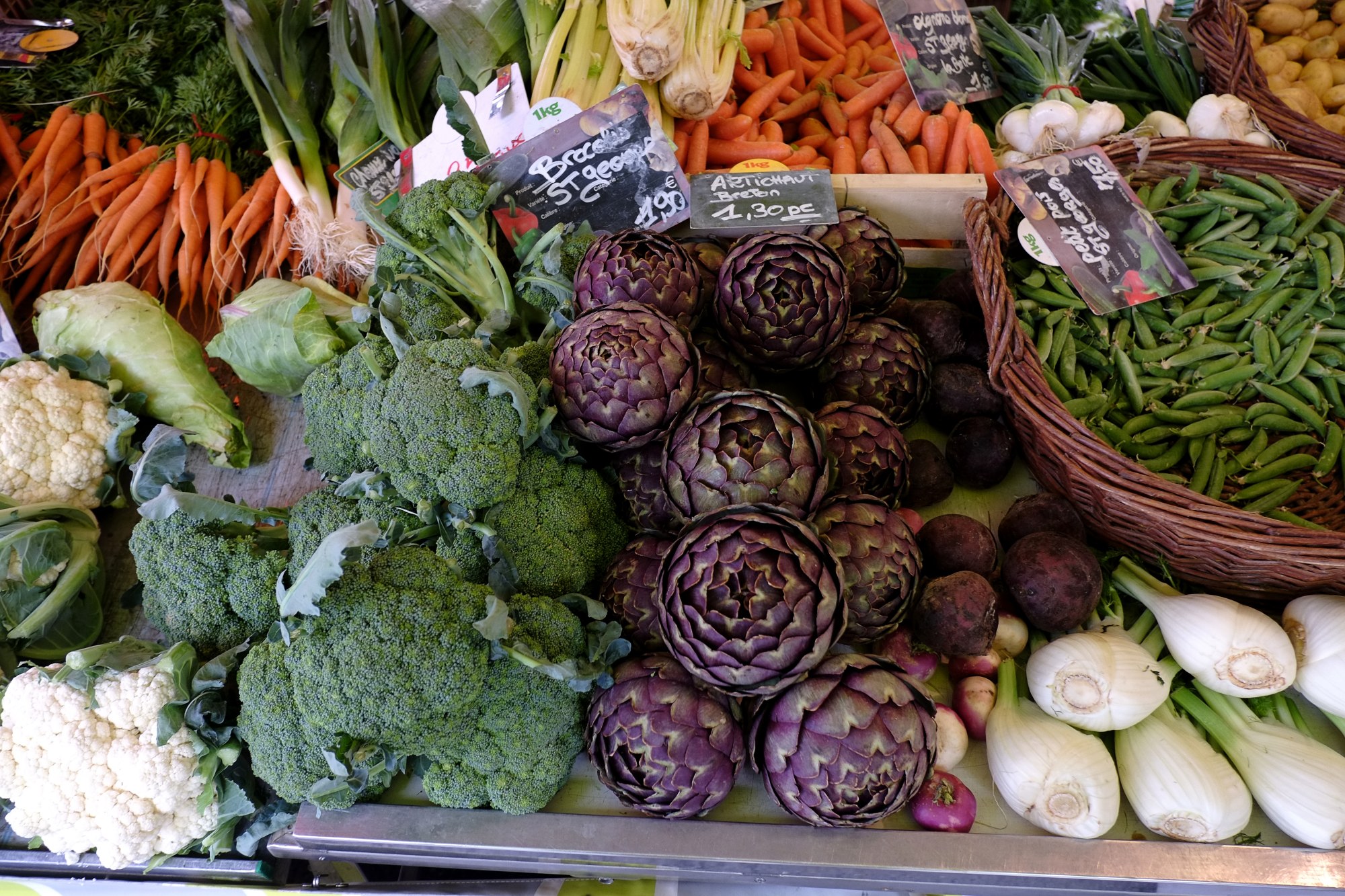 Colourful fresh vegtables, carrots, artichoke, fennel, peas; market day in Le Bois-d'Oingt. Food and travel lifestyle photography by Kent Johnson.