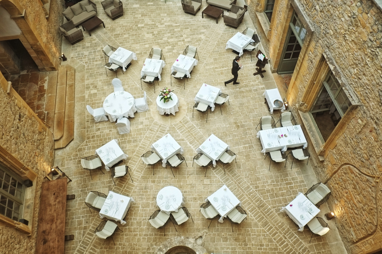 The courtyard of Château de Bagnols with tables set for lunch at restaurant 1217. Hotel and Travel photography by Kent Johnson.
