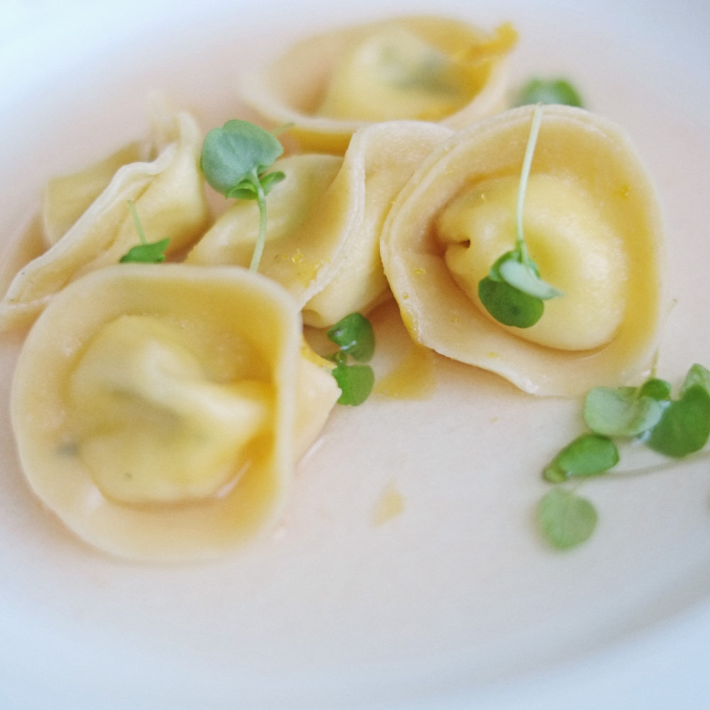 Giovanni Pilu of Pilu at Freshwater's Pecorino Tortellini, Tomato Broth and Bottarga. Photographed by Kent Johnson.