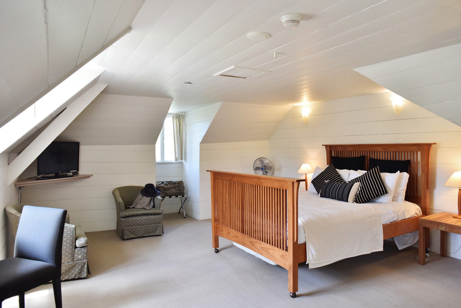 The loft style, Historic Inn Superior Room, dormer windows and timber ceiling details at the Fitzroy Inn. Hotel interior and travel photography by Kent Johnson.