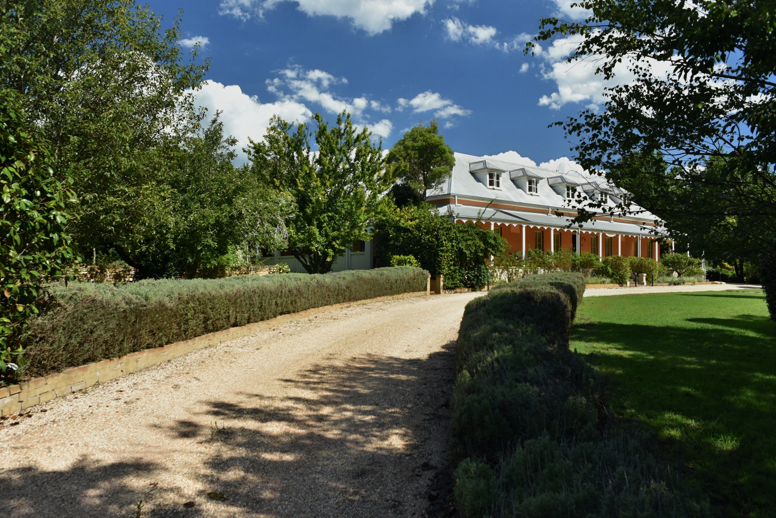 Australian lifestyle photography. The historic Fitzroy Inn Mittagong, Southern Highlands; seen from the long gravel drive and surrounging gardens. Travel and garden photography by Kent Johnson.