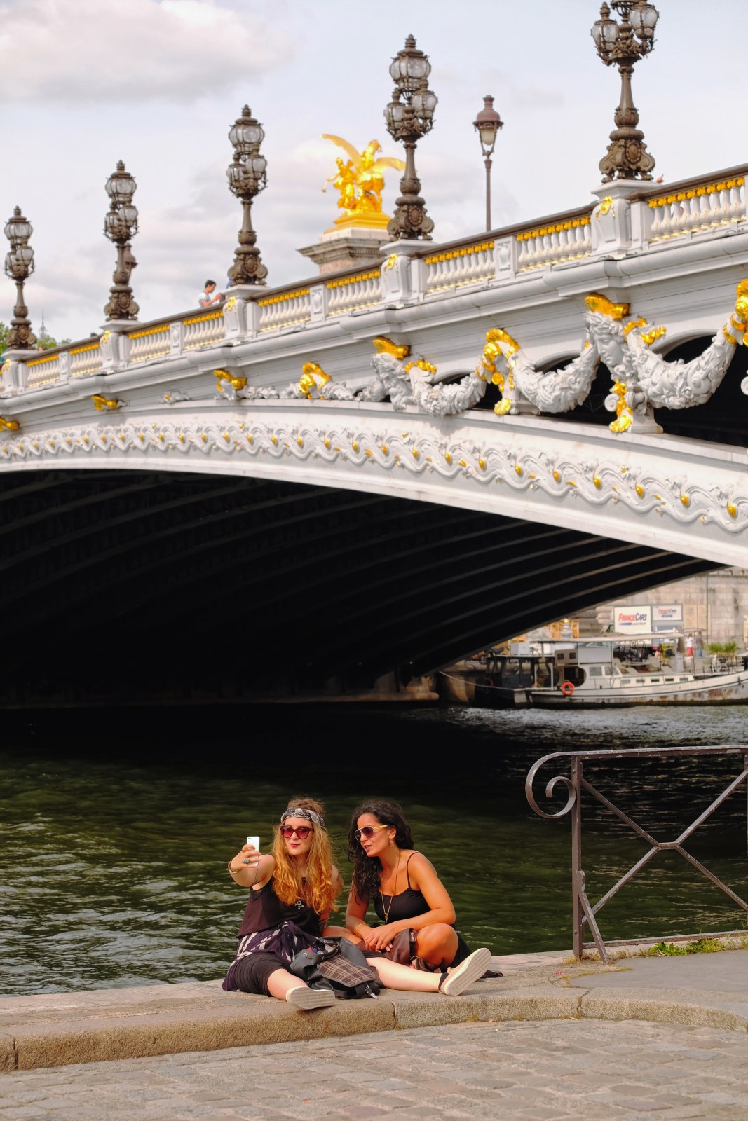 Friends take a selfie quayside, under Pont Alexandre III, Paris, France