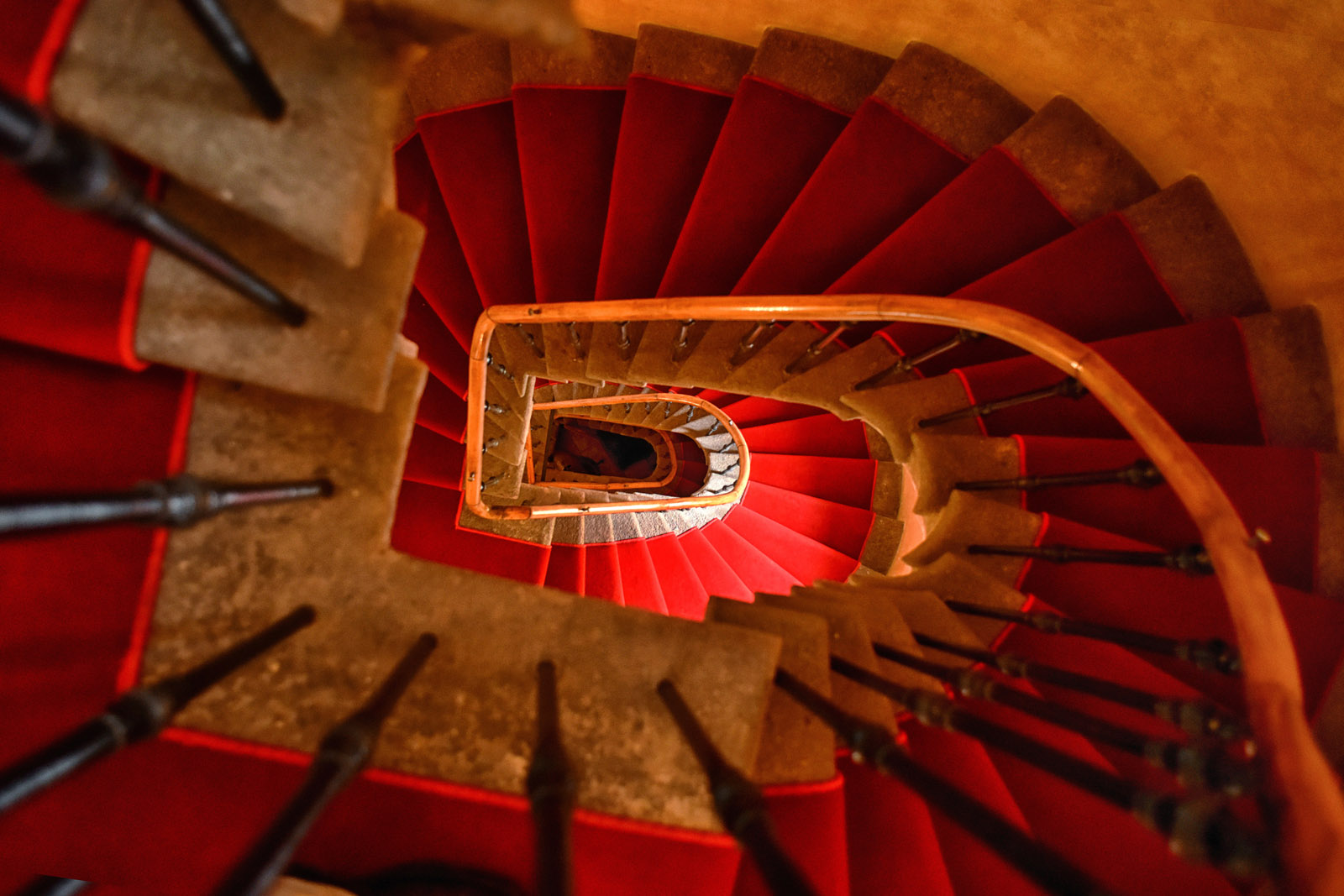 Original spiral staircase with stone treads and iron balustrade, baroque luxury hotel in Prague