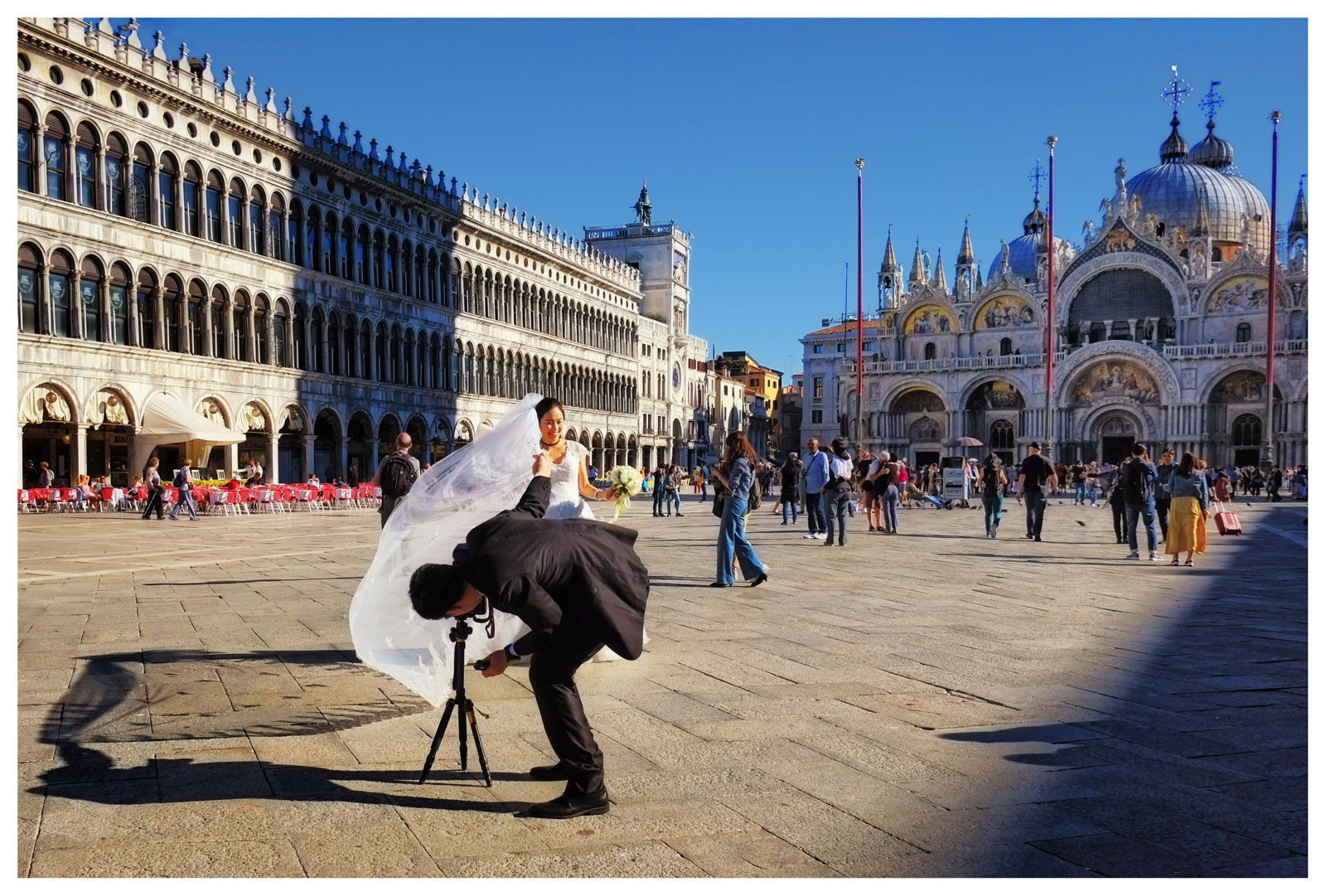 A DIY bride and groom photoshoot in Piazza San Marco with the Basilica San Marco in the backround. Street style travel photography by Kent Johnson.
